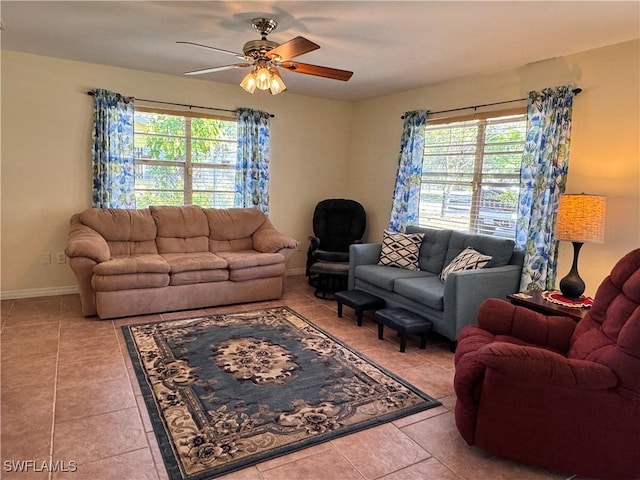 tiled living area with baseboards and a ceiling fan