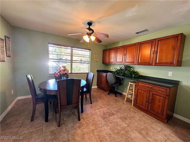 dining space featuring light tile patterned floors, visible vents, built in study area, ceiling fan, and baseboards