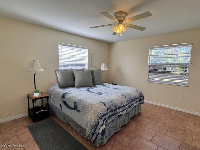 tiled bedroom with a ceiling fan and baseboards