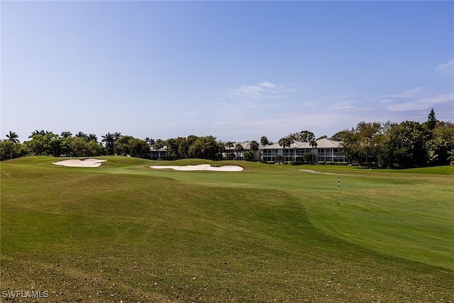 view of home's community featuring view of golf course and a lawn