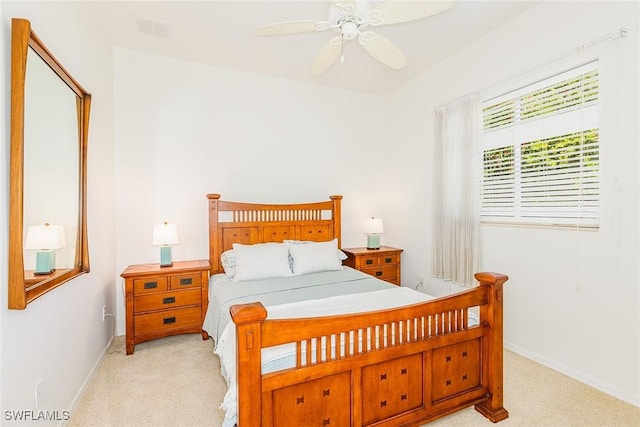 carpeted bedroom featuring a ceiling fan, visible vents, and baseboards