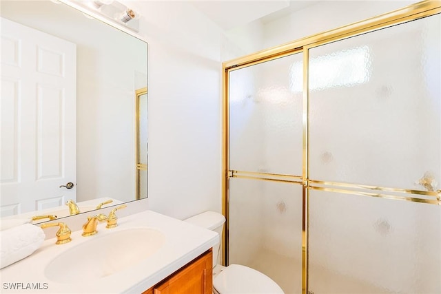 bathroom featuring toilet, a stall shower, and vanity