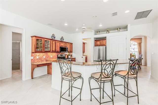 8880 Lely Island Cir, Naples, FL 34113 - kitchen with a kitchen breakfast bar, arched walkways, appliances with stainless steel finishes, and visible vents