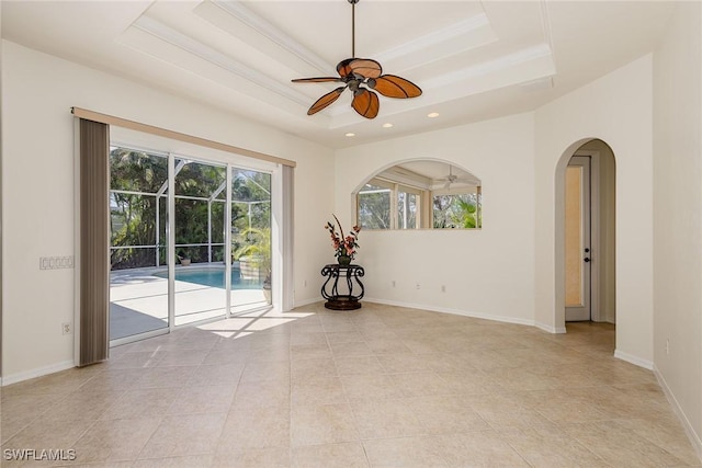 8880 Lely Island Cir, Naples, FL 34113 - spare room featuring arched walkways, a tray ceiling, ceiling fan, and a wealth of natural light