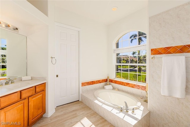 8880 Lely Island Cir, Naples, FL 34113 - bathroom featuring wood finished floors, a garden tub, and vanity