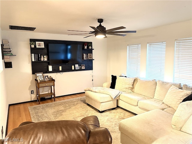 living area featuring visible vents, ceiling fan, and wood finished floors