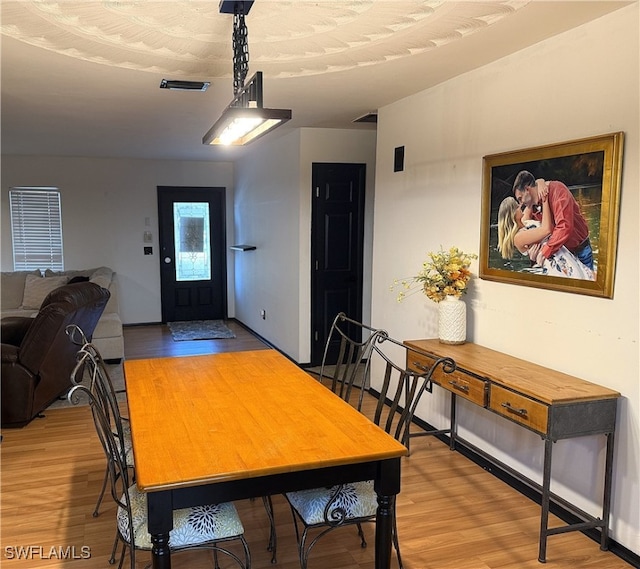 dining space featuring visible vents and light wood-style flooring