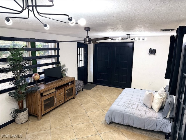 bedroom with light tile patterned floors, visible vents, and a textured ceiling