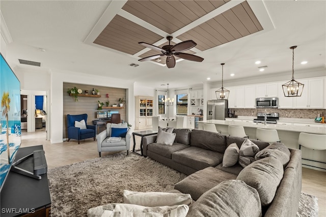 living area with recessed lighting, visible vents, crown molding, and ceiling fan with notable chandelier