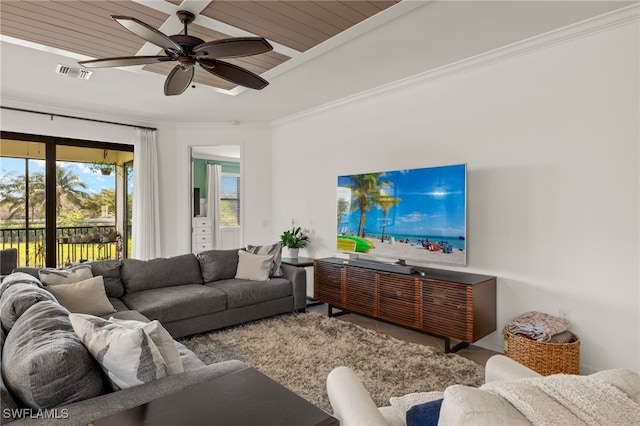 living room with a ceiling fan, visible vents, and crown molding