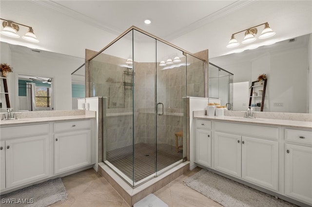 bathroom featuring a shower stall, two vanities, and crown molding