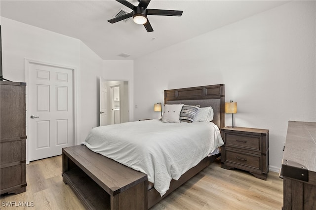 bedroom featuring light wood-style floors, lofted ceiling, visible vents, and a ceiling fan