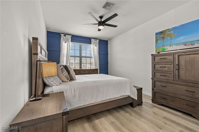 bedroom featuring light wood-type flooring, visible vents, and ceiling fan