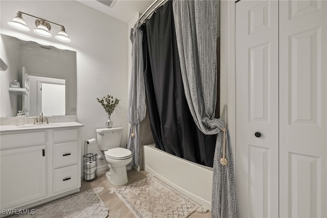 bathroom with a textured wall, toilet, visible vents, vanity, and shower / bath combo with shower curtain