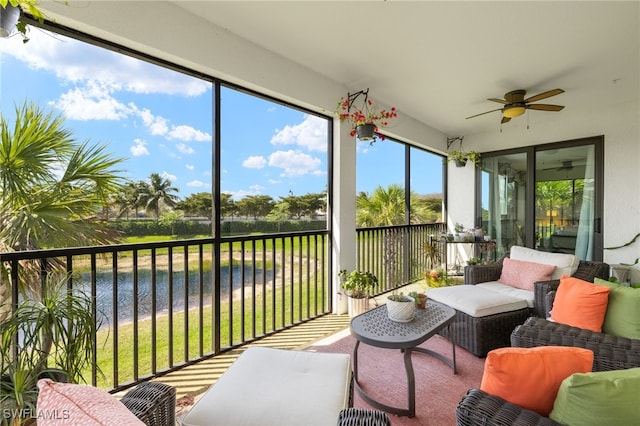 sunroom / solarium with a ceiling fan and a water view