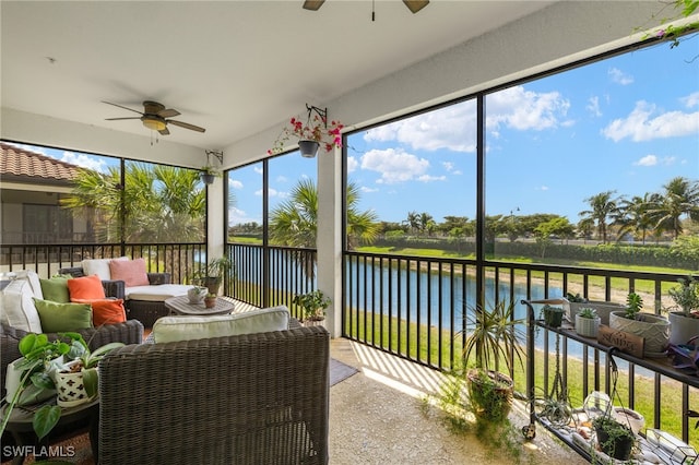 sunroom / solarium featuring ceiling fan and a water view