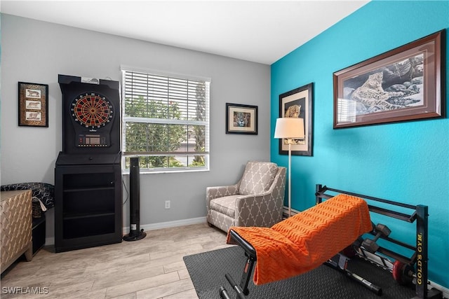 sitting room with baseboards and wood finished floors