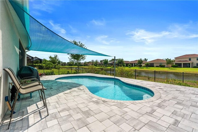 view of pool featuring a patio, a fenced backyard, a water view, and a fenced in pool