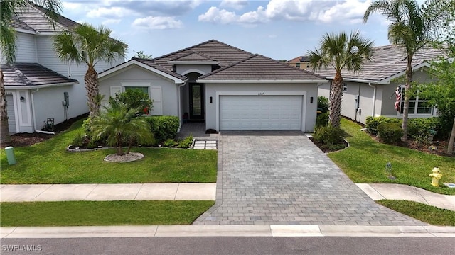 view of front of property with a front lawn, decorative driveway, stucco siding, a tiled roof, and an attached garage