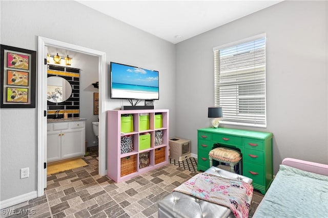 rec room with baseboards and brick patterned floor