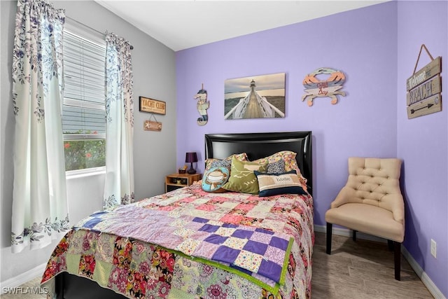 bedroom featuring baseboards and wood finished floors