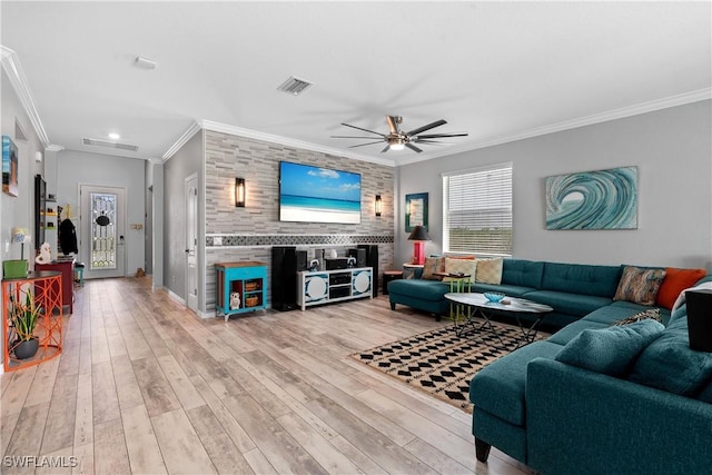 living room featuring crown molding, ceiling fan, light wood finished floors, and visible vents