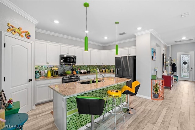 kitchen with white cabinets, backsplash, appliances with stainless steel finishes, and a sink