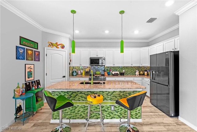 2227 Dancy St, Naples, FL 34120 - kitchen with appliances with stainless steel finishes, crown molding, white cabinets, light stone counters, and tasteful backsplash