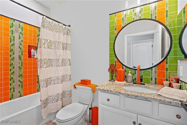 bathroom featuring vanity, shower / tub combo, and toilet