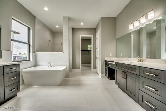 bathroom with a soaking tub, a spacious closet, walk in shower, vanity, and recessed lighting