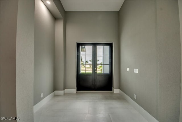 doorway with baseboards and french doors