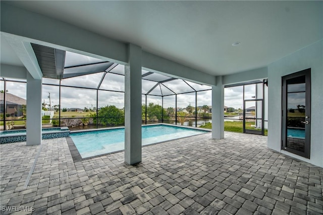 view of pool featuring a lanai, a pool with connected hot tub, and a patio