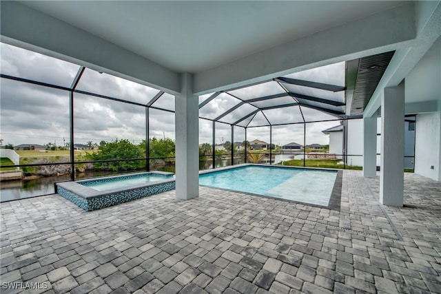 outdoor pool featuring a patio, glass enclosure, and an in ground hot tub