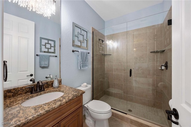 full bathroom with toilet, a stall shower, an inviting chandelier, and vanity