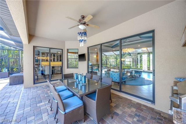 view of patio featuring glass enclosure and a ceiling fan