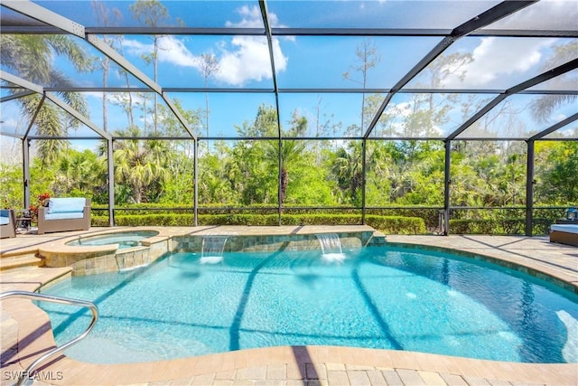 view of pool featuring a pool with connected hot tub, a patio area, and a lanai