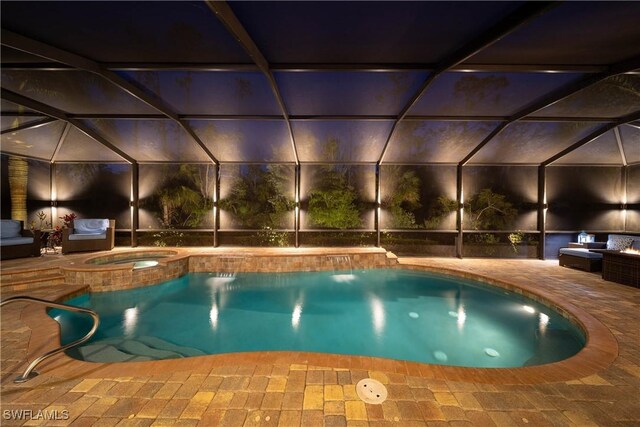 view of pool with a pool with connected hot tub, glass enclosure, and a patio