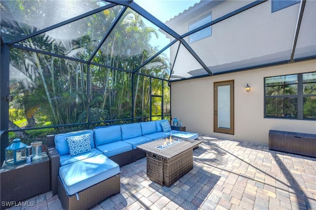 view of patio / terrace with an outdoor living space with a fire pit and a lanai