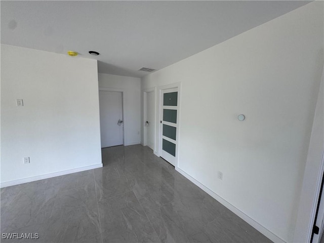 spare room with baseboards and visible vents