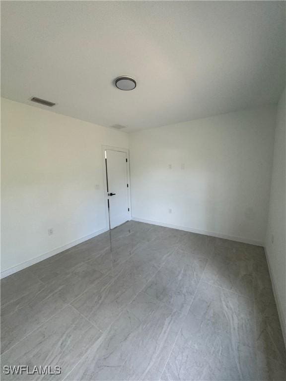 empty room with baseboards and visible vents