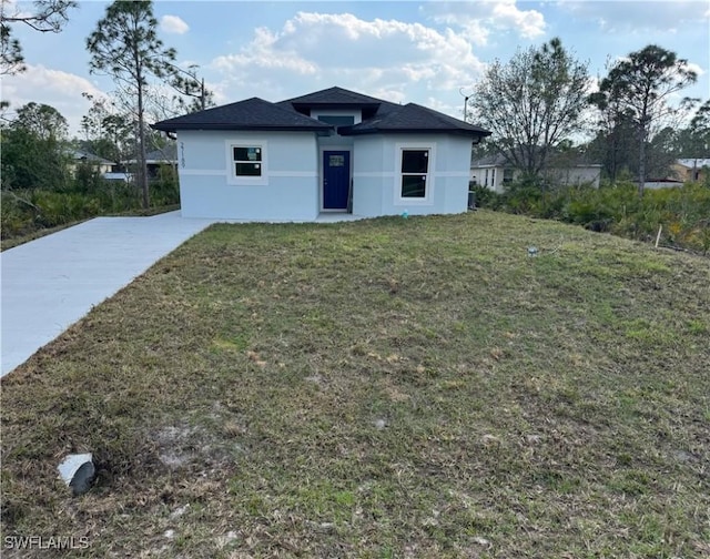 view of front of home with a front lawn and stucco siding