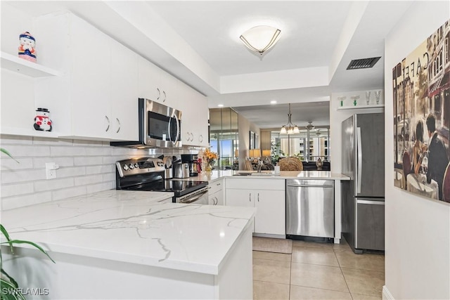 kitchen featuring open shelves, light tile patterned floors, appliances with stainless steel finishes, white cabinets, and a peninsula