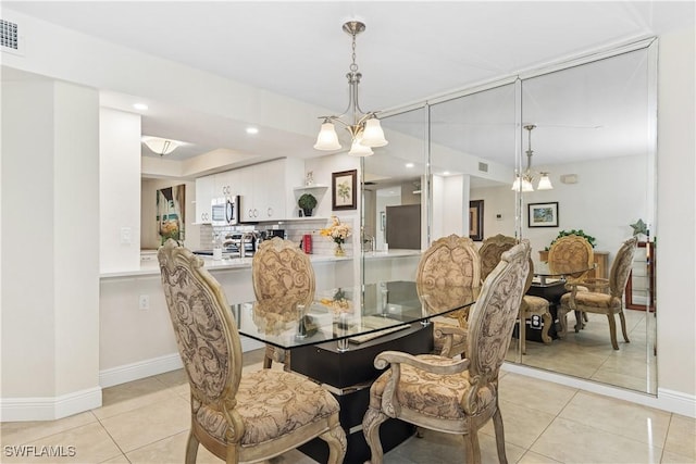 dining space with light tile patterned floors, recessed lighting, baseboards, and a notable chandelier