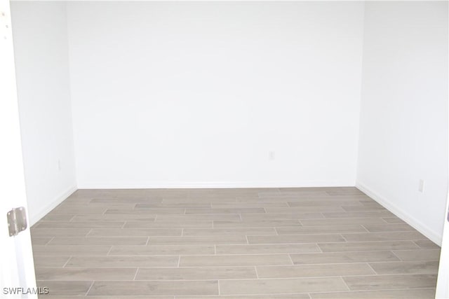 spare room featuring baseboards and wood tiled floor