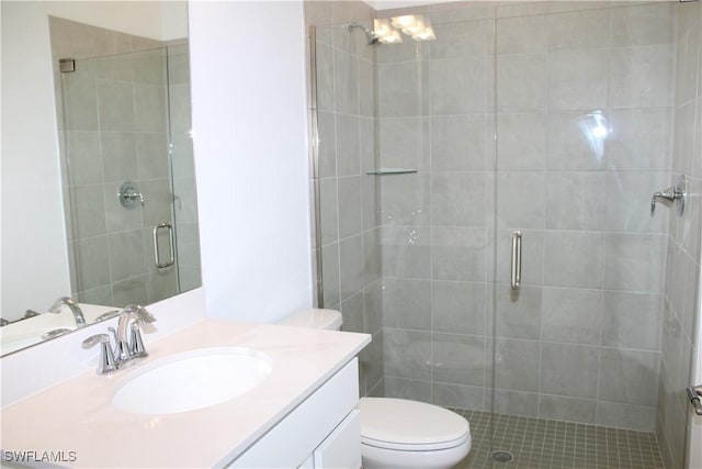 full bath featuring toilet, a stall shower, and vanity