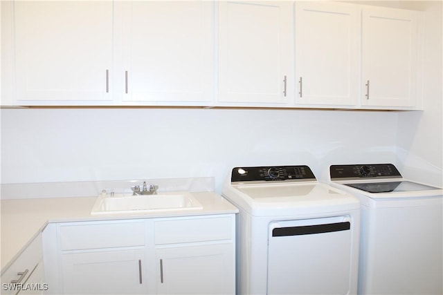 laundry room with separate washer and dryer, a sink, and cabinet space