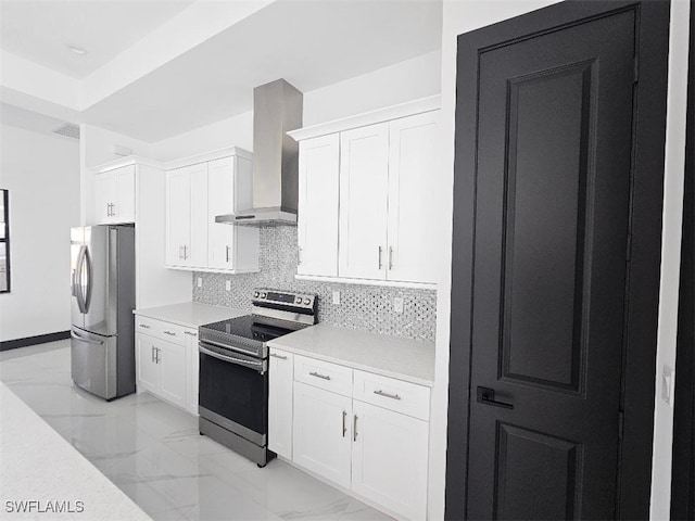 kitchen featuring backsplash, appliances with stainless steel finishes, marble finish floor, white cabinetry, and wall chimney exhaust hood