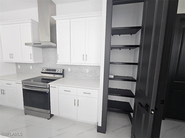 kitchen featuring white cabinetry, electric range, wall chimney exhaust hood, and marble finish floor