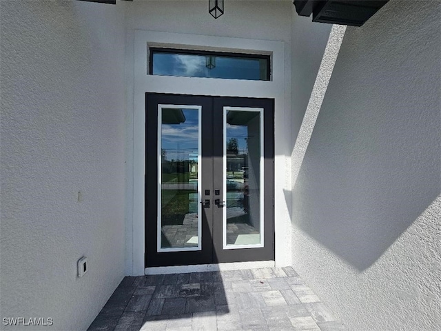 property entrance featuring french doors and stucco siding