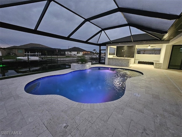 outdoor pool with glass enclosure and a patio